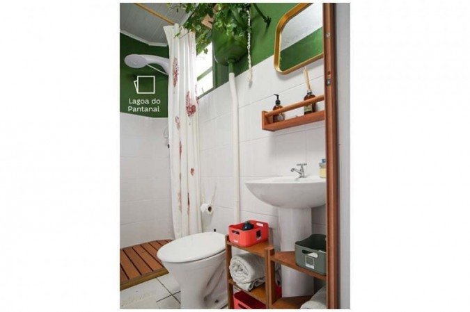 No projeto da Suvinil, o cano e a caixa de descarga ficaram escondidos e o banheiro ganhou uma meia parede colorida