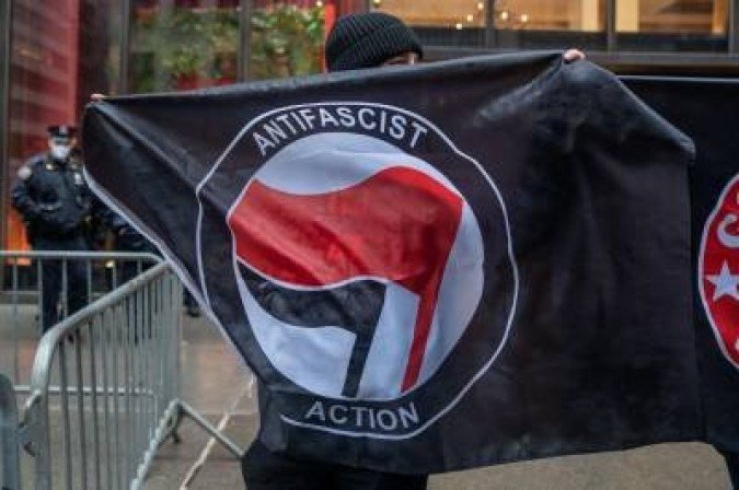 Manifestante segura bandeira do movimento Antifa durante protesto diante da Trump Tower, em Nova York - (crédito: David Dee Delgado) Manifestante segura bandeira do movimento Antifa durante protesto diante da Trump Tower, em Nova York - (crédito: David Dee Delgado)
