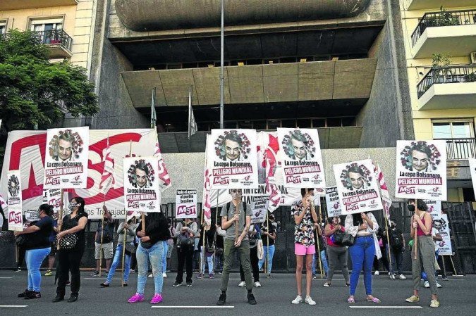 Manifestantes exibem cartazes com os dizeres Manifestantes exibem cartazes com os dizeres