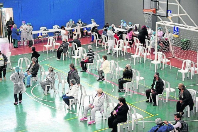 Vacinação em quadra de esportes na Colômbia: sintomas foram mais comuns em mulheres e em pessoas com menos de 50 anos - (crédito: Raul ARBOLEDA/AFP - 7/4/21) Vacinação em quadra de esportes na Colômbia: sintomas foram mais comuns em mulheres e em pessoas com menos de 50 anos - (crédito: Raul ARBOLEDA/AFP - 7/4/21)