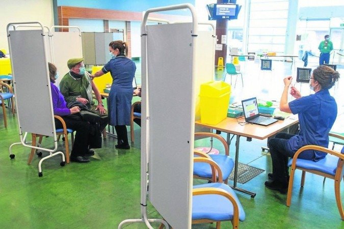 Pacientes são vacinados em centro de imunização em Epsom, no sul da Inglaterra: acompanhamento por núcleos familiares levou em conta grau de periculosidade - (crédito: Dominic Lipinski/AFP) Pacientes são vacinados em centro de imunização em Epsom, no sul da Inglaterra: acompanhamento por núcleos familiares levou em conta grau de periculosidade - (crédito: Dominic Lipinski/AFP)