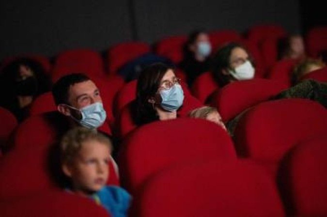 (FILES) In this file photo taken on March 14, 2021 people watch a movie in a cinema theatre, in Nantes, as part of a nationwide action to reopen movie theatres closed since the beginning of the covid-19 pandemic. French President Emmanuel Macron announced on April 29, 2021 that cafes, restaurants, cinemas and museums will reopen partially on May 19, 2021 after seven months amidst the coronavirus pandemic. / AFP / LOIC VENANCE -  (crédito: LOIC VENANCE)
