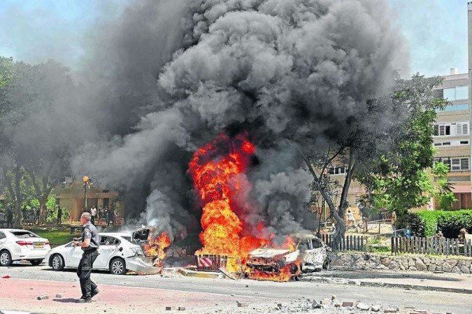 Em Ashkelon, carros em chamas depois de serem atingidos por foguete 