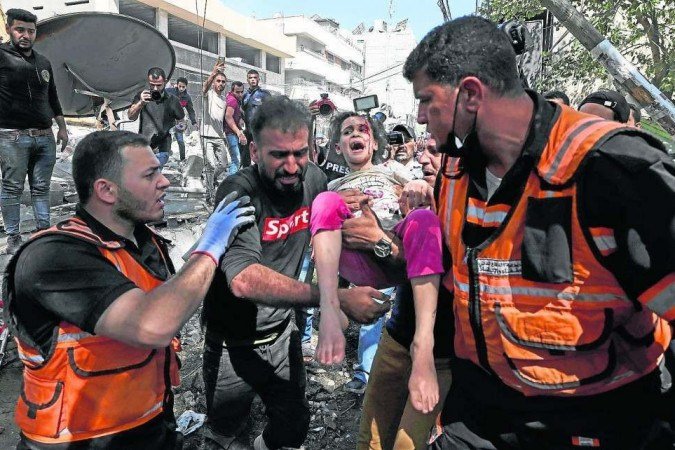 Paramédicos socorrem criança retirada dos escombros de prédio destruído por míssil, no bairro de Al-Rimal, na Cidade de Gaza -  (crédito: Mahmud Hams/AFP)