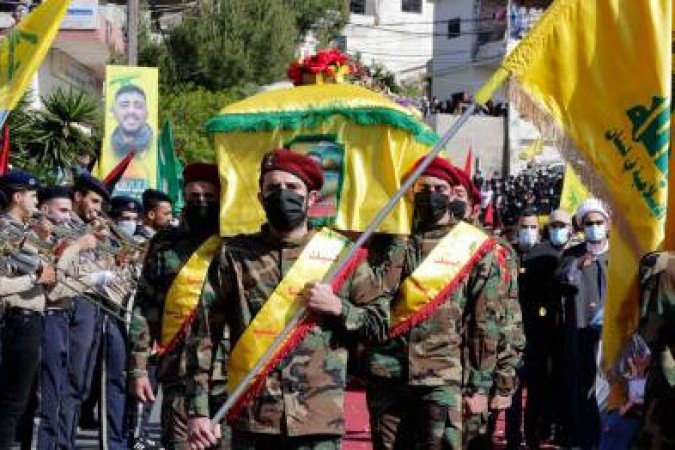 (FILES) In this file photo taken on May 15, 2021 Members of the Iran-backed Hezbollah movement, carry the coffin of Mohamad Kassem Tahan, a fellow member killed a day earlier by Israeli shelling on the frontier with Lebanon during a protest against the latest assault on the Gaza Strip, at his funeral in the southern Lebanese village of Adloun. Israel's deadly Gaza offensive has many eyes trained on the Lebanese border for a Hezbollah reaction but observers argue the Iran-backed movement is unlikely to risk an all-out conflict. Hezbollah and the Palestinian Hamas, both designated as terrorist groups by Israel and much of the West, have mended fences after ending up on opposing sides of the Syrian war a decade ago. / AFP / Anwar AMRO