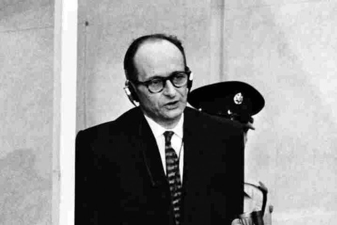 (ARQUIVOS) Esta foto de arquivo tirada em 11 de abril de 1961 mostra o criminoso de guerra nazista Adolf Eichmann em pé em seu cais à prova de balas durante o primeiro dia de seu julgamento em frente a um tribunal israelense, 11 de abril de 1961, em Jerusalém. O presidente israelense Reuven Rivlin deve tornar públicos documentos inéditos, incluindo um pedido manuscrito de clemência do criminoso de guerra nazista Adolf Eichmann, no Dia Internacional em Memória do Holocausto em 27 de janeiro de 2016. Ex-líder da SS nazista e um dos principais organizadores dos campos de extermínio na Europa Oriental ocupada pelos nazistas, foi capturado por agentes israelenses do Mossad na Argentina, indiciado por um tribunal israelense por 15 acusações criminais, incluindo acusações de crimes contra a humanidade, crimes contra o povo judeu e filiação a uma organização ilegal. Ele foi condenado à morte em 15 de dezembro de 1961 e executado em 1962 em Jerusalém. / AFP / -