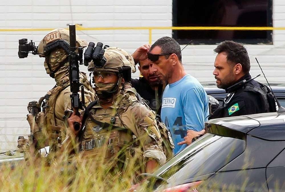 The leader of Brazilian criminal organization First Capital Command (PCC) Marcos Camacho, aka Marcola, is escorted before boarding a helicopter after getting medical assistance at a hospital in Brasilia, on January 21, 2020. Marcola is serving a sentence for drug trafficking at the federal prison in Brasilia. / AFP / Sergio LIMA