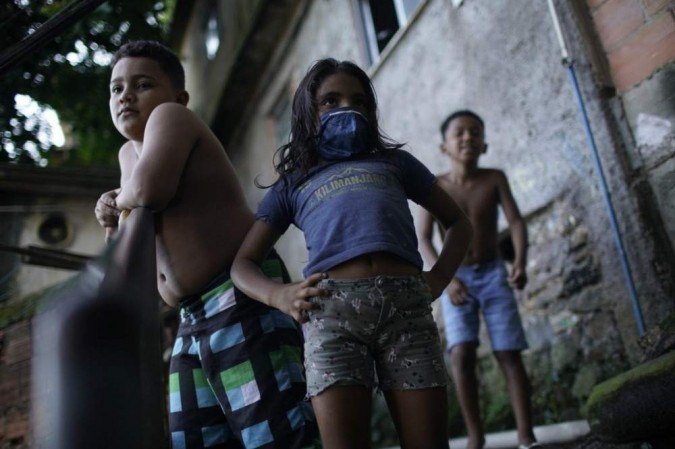 Na foto, crianças assistem desinfecção no Rio de Janeiro para conter a covid-19. Maior parte das escolas públicas no país está fechada desde o início da pandemia - (crédito: Mauro Pimentel/AFP) Na foto, crianças assistem desinfecção no Rio de Janeiro para conter a covid-19. Maior parte das escolas públicas no país está fechada desde o início da pandemia - (crédito: Mauro Pimentel/AFP)