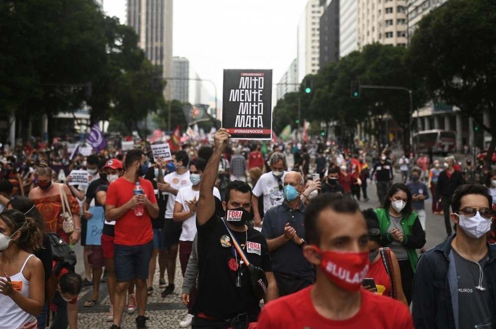 Um manifestante segura uma placa dizendo 'Mito mente, mito mata' durante um protesto contra o tratamento da pandemia Covid-19 pelo presidente brasileiro Jair Bolsonaro no Rio de Janeiro, Brasil, em 19 de junho de 2021. O presidente de extrema direita Jair Bolsonaro vem enfrentando críticas por sua gestão da pandemia, incluindo inicialmente recusar ofertas de vacinas, como os epidemiologistas alertam que o Brasil pode agora estar à beira de uma terceira onda de Covid-19.
Andre Borges / AFP