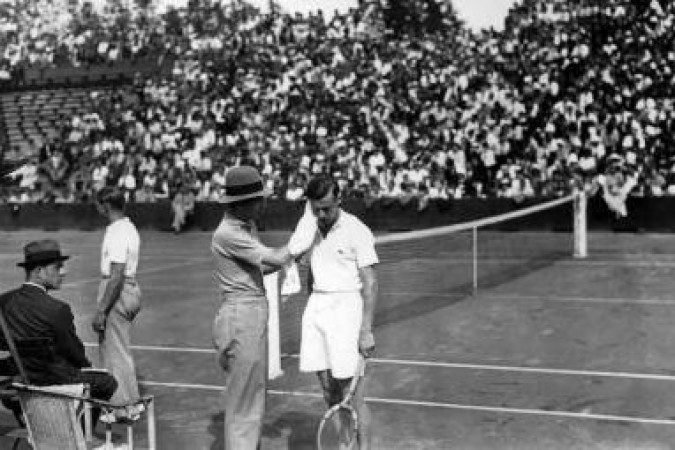 Captain René Lacoste (L) dries French tennisman Christian Boussus's face (R) during the Davis Cup in June 1935 in Wimbledon. / AFP / -