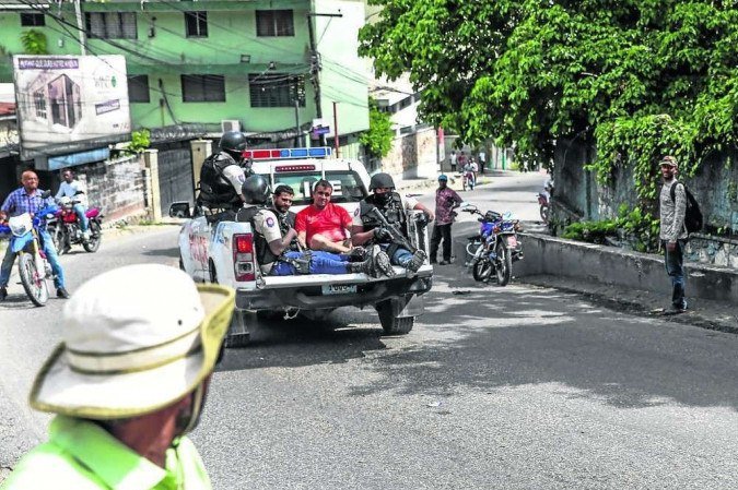 Dois supostos mercenários que teriam executado Moïse são levados pela polícia à delegacia do bairro de Pétion-Ville, em Porto Príncipe -  (crédito: Valerie Baeriswyl/AfP)