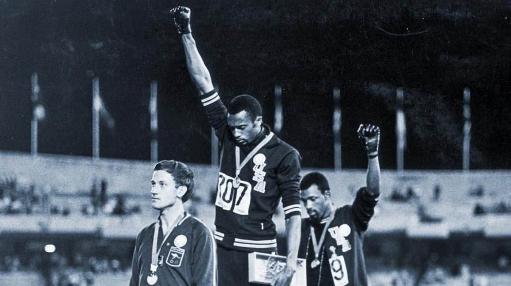 Em 1968, os atletas americanos Tommie Smith e John Carlos protestaram contra o racismo nos Estados Unidos, ao subirem no pódio dos 200 metros rasos no México. De luvas pretas e cabeça abaixada, eles ergueram as mãos ao céu, fazendo o gesto de resistência da saudação Black Power / Olimpíadas