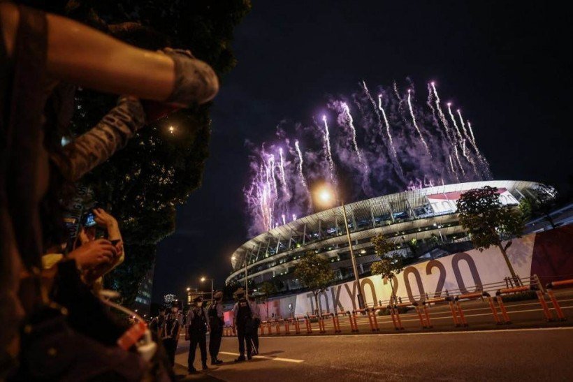 Supporters gather to watch the fireworks light up the sky over the Olympic Stadium during the opening ceremony of the Tokyo 2020 Olympic Games, in Tokyo, on July 23, 2021.
Behrouz MEHRI / AFP