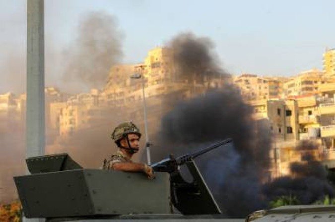 TOPSHOT - A Lebanese soldier sits in an armoured vehicle as the army deploys amid clashes in the Khalde area, south of the capital, on August 1, 2021. At least five people including three Hezbollah members were killed south of Beirut when a funeral procession for a party member was ambushed, a Lebanese security source told AFP, adding that several people were wounded in the exchange of fire in the Khalde area between members of the Lebanese Shiite group and Sunni residents. (Photo by ANWAR AMRO / AFP) - (crédito: ANWAR AMRO) TOPSHOT - A Lebanese soldier sits in an armoured vehicle as the army deploys amid clashes in the Khalde area, south of the capital, on August 1, 2021. At least five people including three Hezbollah members were killed south of Beirut when a funeral procession for a party member was ambushed, a Lebanese security source told AFP, adding that several people were wounded in the exchange of fire in the Khalde area between members of the Lebanese Shiite group and Sunni residents. (Photo by ANWAR AMRO / AFP) - (crédito: ANWAR AMRO)