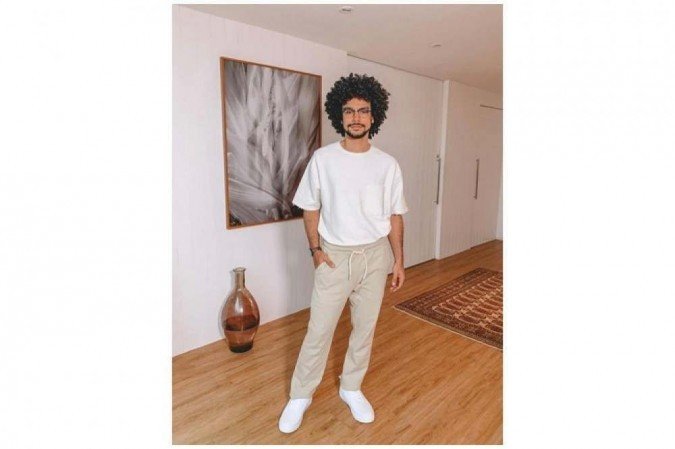 Com pegada loungewear, Sérgio Malheiros usa calça de moletom em tom areia. A camiseta com caimento mais largo ajuda a tirar o look do básico