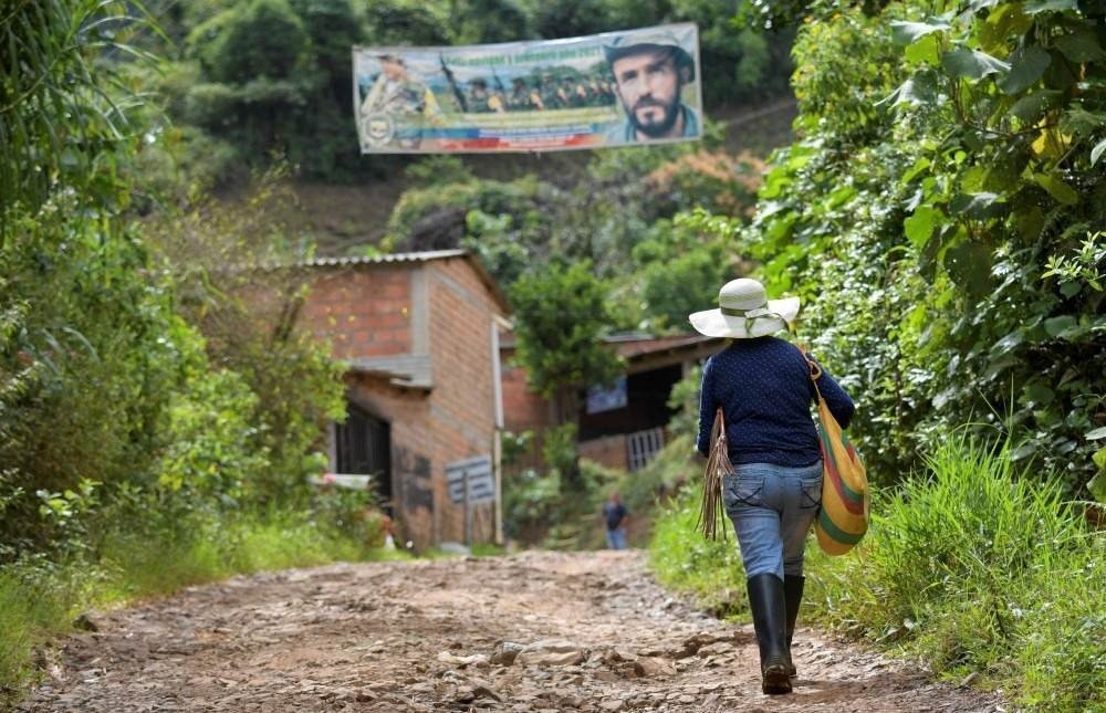 A woman walks in the mountains of El Patia municipality, Cauca department, Colombia, on May 3, 2021. In the mountains and jungles of southwestern Colombia, peasants, migrants and women carrying babies toil determinedly in fields of coca despite the dangers and persecution they suffer, whilst Colombian President Ivan Duque issued a decree to reactivate the use of aerial glyphosate spraying in illicit coca crops.