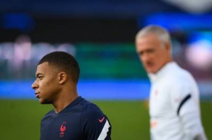 France's forward Kylian Mbappe (L) reacts next to France's coach Didier Deschamps (R) during a training session at the Meineau stadium in Strasbourg, eastern France, on August 31, 2021 on the eve of the FIFA World Cup Qatar 2022 qualification Group D football match between France and Bosnia-Herzegovina. (Photo by FRANCK FIFE / AFP)