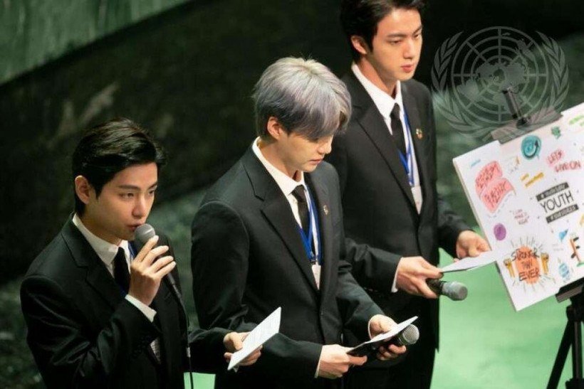 
V do BTS (à esquerda), Enviado Especial do Presidente para as Gerações Futuras e Cultura da República da Coreia, faz comentários e se apresenta durante o Momento dos Objetivos de Desenvolvimento Sustentável (ODS), enquanto Suga (cente) e Jin observam.  