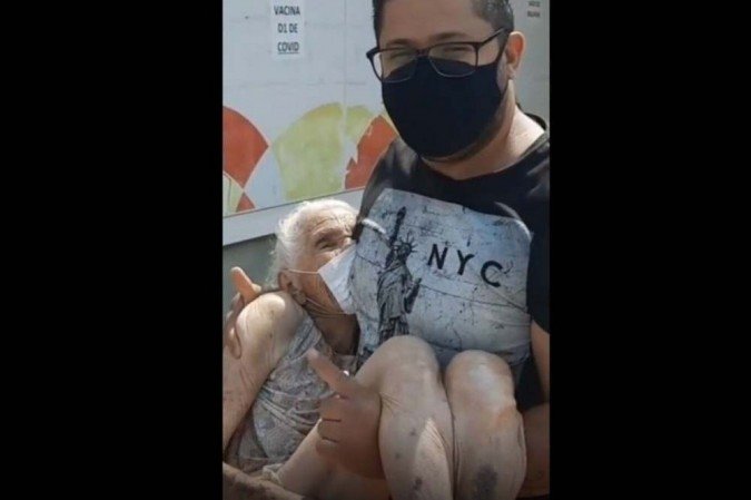 Erick Farias precisou carregar a avó para que ela pudesse receber a terceira dose da vacina contra a covid-19 -  (crédito: Redes sociais/Reprodução)
