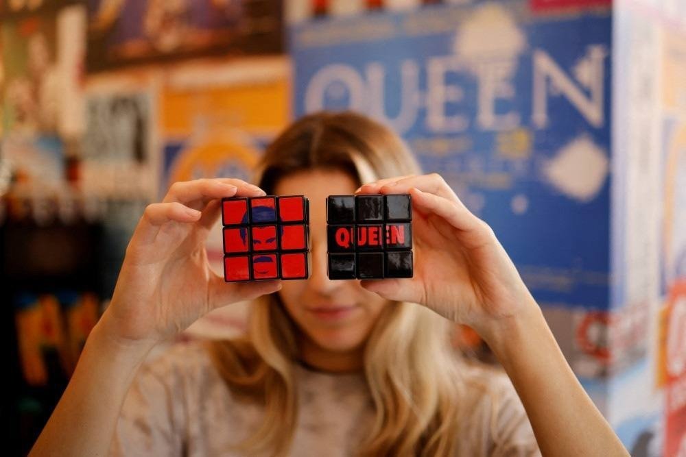A shop assistant poses with official merchandise of legendary British rock group Queen on sale at their newly opened store in central London on September 27, 2021.
