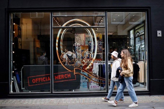 Pedestrians walk past the windows of a new store selling official merchandise of legendary British rock group Queen in central London on September 27, 2021. -  (crédito: Tolga Akmen / AFP)