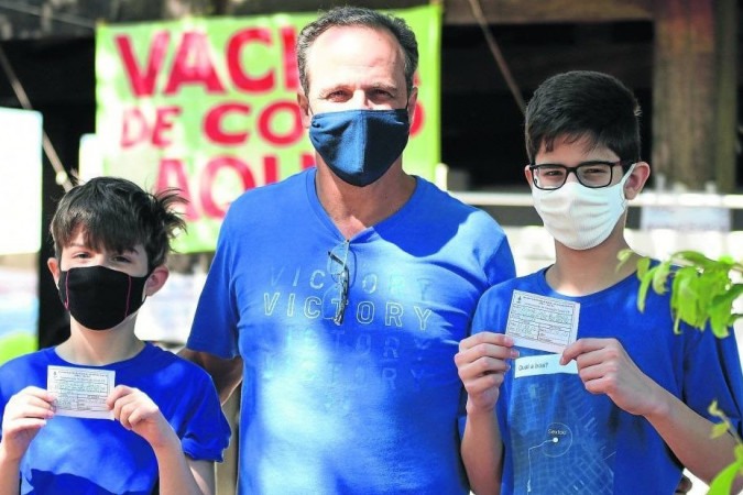 José Eduardo Lins, 54 anos, levou os filhos Enzo, 12, e Bernardo, 13, para se vacinarem. 