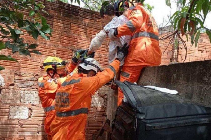 Momento em que os bombeiros retiram o menino de cima do muro, já com o braço imobilizado -  (crédito: CBMMG)