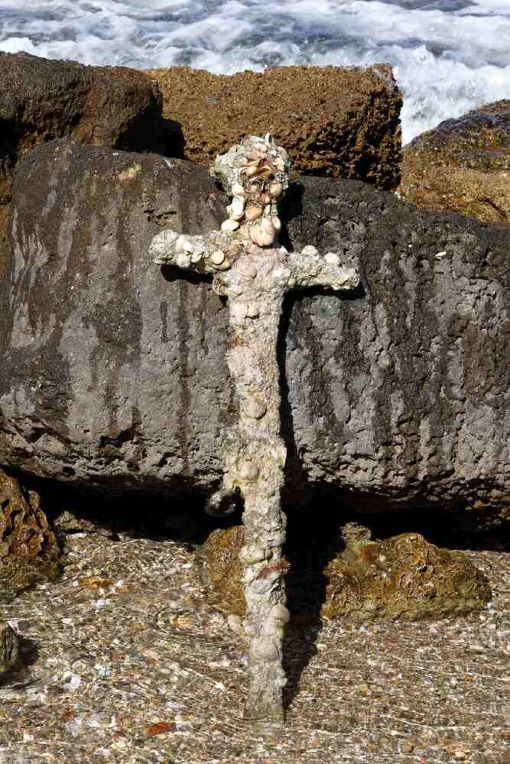 A picture taken on October 19, 2021, shows an ancient one-meter-long sword that experts say dates back to the Crusader-era and is believed to have belonged to a Crusader, displayed at the beach in the Israeli seaport of Caesarea, some days after being discovered by a local diver. (Photo by Jack GUEZ / AFP)