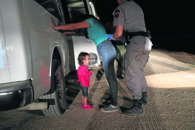 Policial da Patrulha Fronteiriça revista hondurenha, enquanto a filha de 2 anos chora, após tentarem entrar nos EUA, em 2018: foto viralizou  -  (crédito: John Moore/AFP)