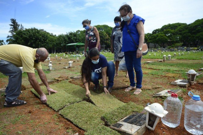27/10/2021 Crédito: Marcelo Ferreira/CB/D.A Press. Brasil. Brasilia - DF Cemitério Campo da Esperança em Taguatinga, preparativos para o dia dos finados. Descaso e abandono. Antônia Ferreira (calça vinho) e familiares arrumam o túmulo da família