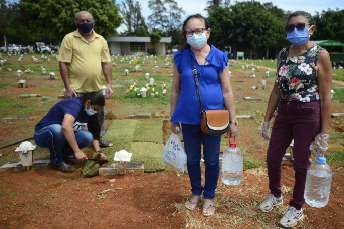 27/10/2021 CrÃ©dito: Marcelo Ferreira/CB/D.A Press. Brasil. Brasilia - DF CemitÃ©rio Campo da EsperanÃ§a em Taguatinga, preparativos para o dia dos finados. Descaso e abandono. AntÃŽnia Ferreira (calÃ§a vinho) com FÃ¡tima Dantas (camisa azul) e familiares arrumam o tÃºmulo da famÃ­lia