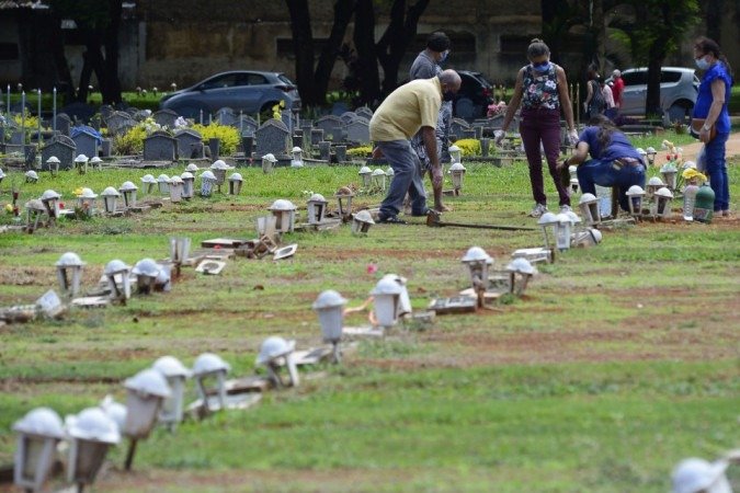 27/10/2021 Crédito: Marcelo Ferreira/CB/D.A Press. Brasil. Brasilia - DF Cemitério Campo da Esperança em Taguatinga, preparativos para o dia dos finados. Descaso e abandono. Antônia Ferreira (calça vinho) e familiares arrumam o túmulo da família