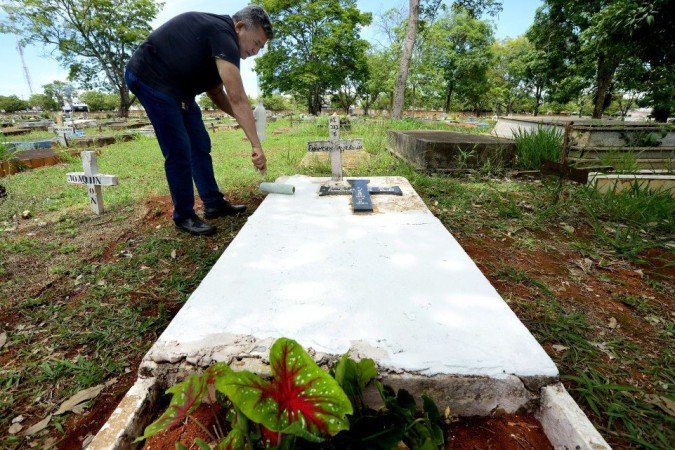 27/10/2021 Crédito: Marcelo Ferreira/CB/D.A Press. Brasil. Brasilia - DF Cemitério Campo da Esperança em Taguatinga, preparativos para o dia dos finados. Descaso e abandono. Raimundo Marques, pinta o túmulo da família.