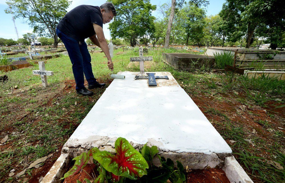 27/10/2021 Crédito: Marcelo Ferreira/CB/D.A Press. Brasil. Brasilia - DF Cemitério Campo da Esperança em Taguatinga, preparativos para o dia dos finados. Descaso e abandono. Raimundo Marques, pinta o túmulo da família.