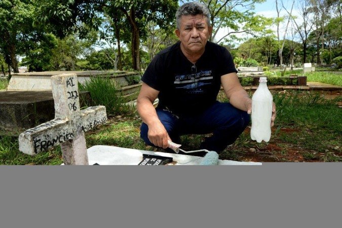 27/10/2021 Crédito: Marcelo Ferreira/CB/D.A Press. Brasil. Brasilia - DF Cemitério Campo da Esperança em Taguatinga, preparativos para o dia dos finados. Descaso e abandono. Raimundo Marques, pinta o túmulo da família.