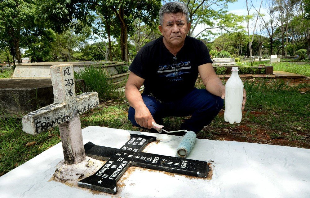 27/10/2021 Crédito: Marcelo Ferreira/CB/D.A Press. Brasil. Brasilia - DF Cemitério Campo da Esperança em Taguatinga, preparativos para o dia dos finados. Descaso e abandono. Raimundo Marques, pinta o túmulo da família.