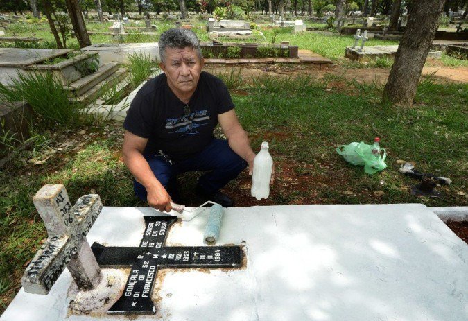 27/10/2021 Crédito: Marcelo Ferreira/CB/D.A Press. Brasil. Brasilia - DF Cemitério Campo da Esperança em Taguatinga, preparativos para o dia dos finados. Descaso e abandono. Raimundo Marques, pinta o túmulo da família.