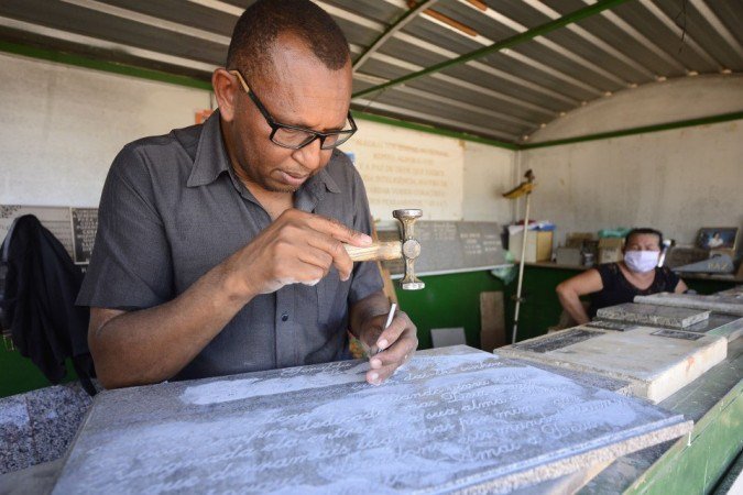 27/10/2021 Crédito: Marcelo Ferreira/CB/D.A Press. Brasil. Brasilia - DF Comércio preparativos para o dia dos finados. Cemitério Campo da Esperança na Asa Sul. Nivaldo de Souza, letrista escreve da lapídes de mármore.