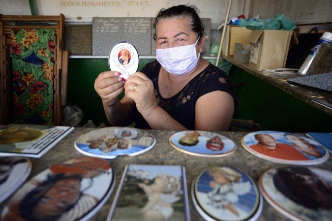 27/10/2021 Crédito: Marcelo Ferreira/CB/D.A Press. Brasil. Brasilia - DF Comércio preparativos para o dia dos finados. Cemitério Campo da Esperança na Asa Sul. Norma Lucia, confecciona fotos para colocar nas lapídes.