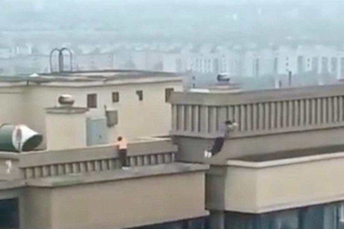 Um registro feito na província chinesa de Hubei de duas crianças brincando no telhado de um prédio de 27 andares tem dado calafrios a quem assiste - (crédito: South China Morning Post/Reprodução) Um registro feito na província chinesa de Hubei de duas crianças brincando no telhado de um prédio de 27 andares tem dado calafrios a quem assiste - (crédito: South China Morning Post/Reprodução)