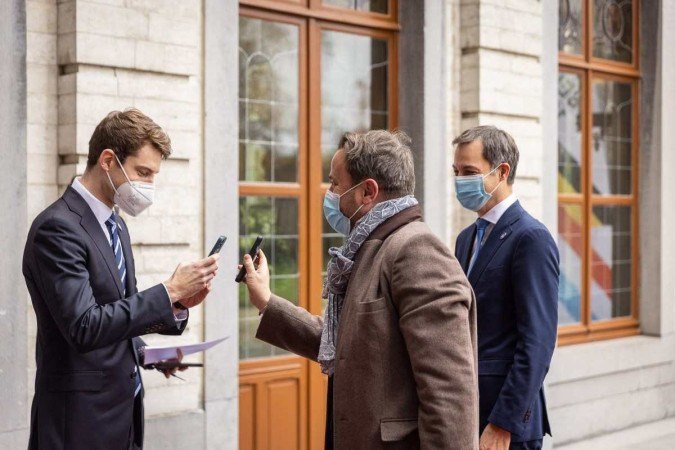 Os premiês Xavier Bettel (C), de Luxemburgo, e Alexander De Croo (E), da Bélgica, apresentam passaporte de vacinação em evento sobre economia dos dois países, em Bruxelas 