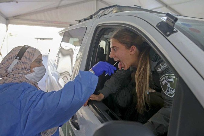 Médico coleta secreção de guarda fronteiriço de Israel, em local de testagem de Jerusalém