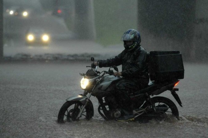 Motociclista se arrisca em meio à enxurrada