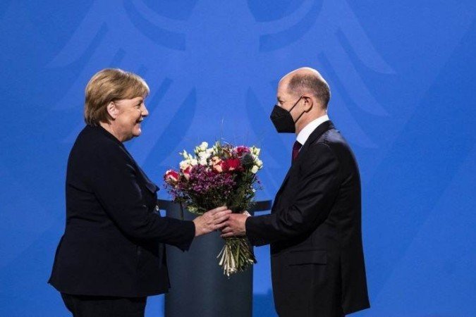 O chanceler Olaf Scholz recebendo flores da sua predecessora Angela Merkel - (crédito: AFP) O chanceler Olaf Scholz recebendo flores da sua predecessora Angela Merkel - (crédito: AFP)