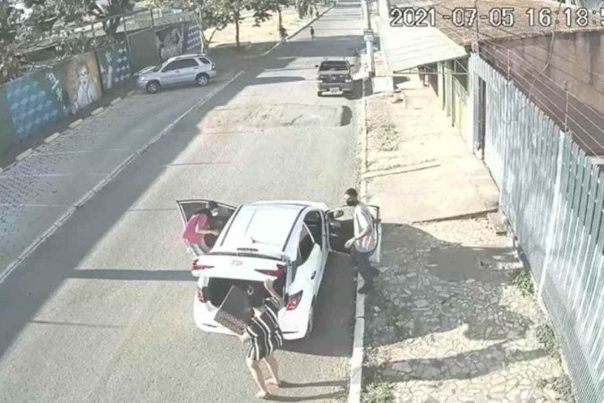 Na imagem retirada do vídeo, dois homens armados abordam a motorista de aplicativo e levam o carro. - (crédito: Polícia Civil do DF) Na imagem retirada do vídeo, dois homens armados abordam a motorista de aplicativo e levam o carro. - (crédito: Polícia Civil do DF)