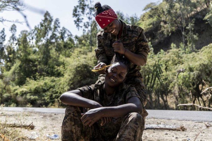 Soldado das Forças de Defesa Nacional da Etiópia tem a ajuda de colega para prender cabelo, em Hayk 
