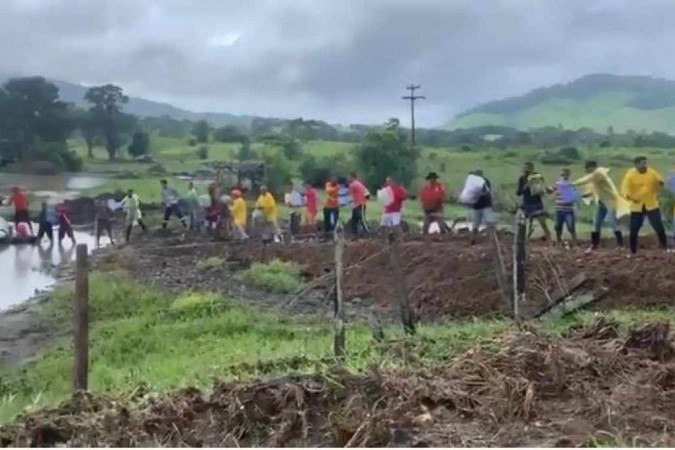 Com estrada destruída pelas chuvas, moradores fazem corrente para garantir doações