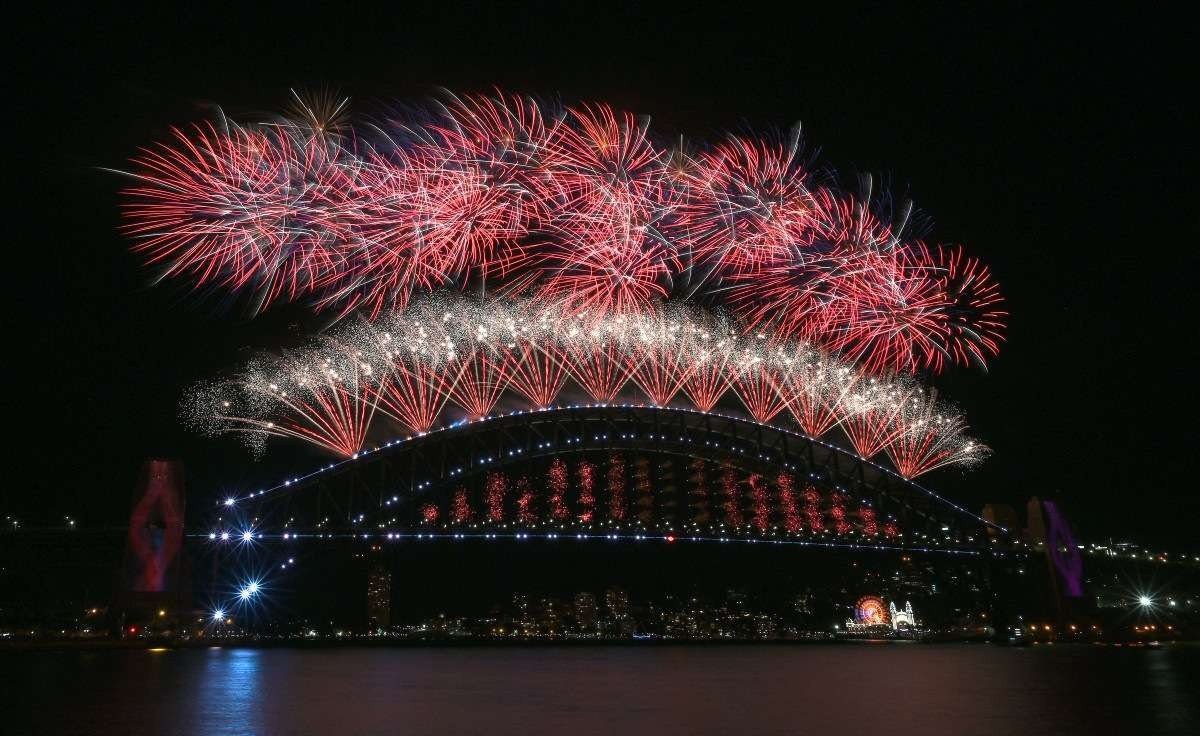  New Year's Eve fireworks light up the sky over Sydney's iconic Harbour Bridge during the fireworks show on January 1, 2022. (Photo by Mohammad FAROOQ / AFP)
      