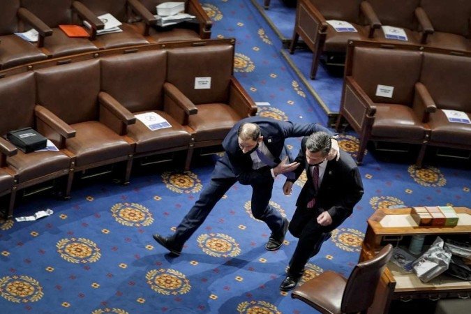 Policial legislativo resgata o deputado Dan Me (D) de plenário - (crédito: Drew Angerer/Getty Images/AFP - 6/1/21) Policial legislativo resgata o deputado Dan Me (D) de plenário - (crédito: Drew Angerer/Getty Images/AFP - 6/1/21)