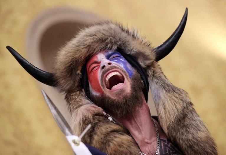 Conhecido como "Xamã Q", Jake Angeli grita dentro do Capitólio